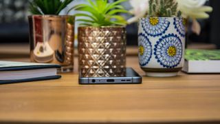 Smartphone and book on desk in front of small pot plants