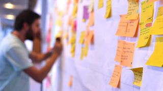 Man working on Kanban board to signify agile development