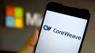 CoreWeave logo and branding pictured on a smartphone with Microsoft logo blurred in background.