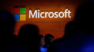 Microsoft logo illuminated on a wall during a Microsoft launch event to introduce the new Microsoft Surface laptop and Windows 10 S operating system, May 2, 2017 in New York City. 