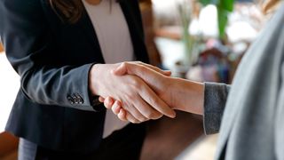 Two female business people shaking hands.